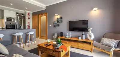 a living room with a couch and a flat screen tv at #093 Vista das Ondas by Home Holidays in Albufeira