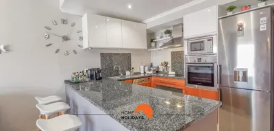 a kitchen with a counter and a clock on the wall at #093 Vista das Ondas by Home Holidays in Albufeira