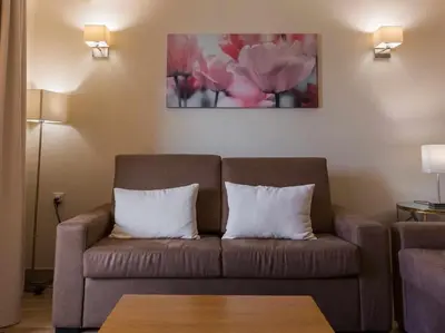 a living room with a brown couch with two pillows at Albufeira Sol Villas I by Stay ici Algarve Holiday Rental in Albufeira