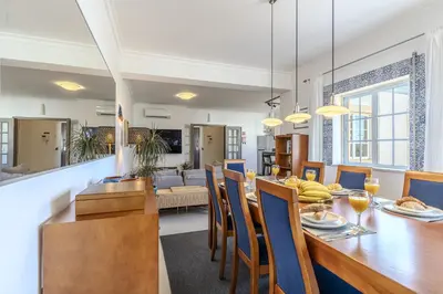 a dining room with a wooden table and chairs at #056 Old Post Office by Home Holidays in Albufeira