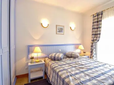 a bedroom with a bed and two lamps and a window at Akisol Olhos de Água Ocean in Albufeira