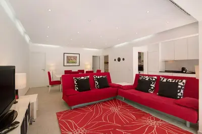 a living room with red couches and a red rug at Large apartment in Vale do Lobo in Almancil