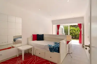 a bedroom with a bed and a red rug at Large apartment in Vale do Lobo in Almancil
