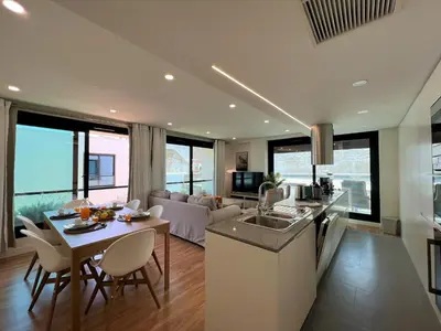 a kitchen and living room with a couch and a table at Faro Design 1 by Homing in Faro