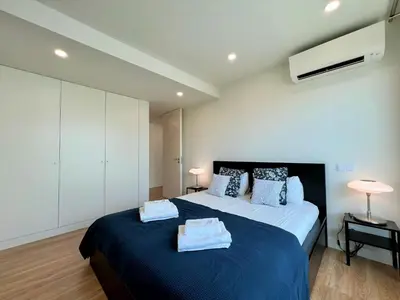 a bedroom with a large bed with towels on it at Faro Design 1 by Homing in Faro
