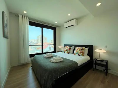 a bedroom with a bed with a large window at Faro Design 3 by Homing in Faro