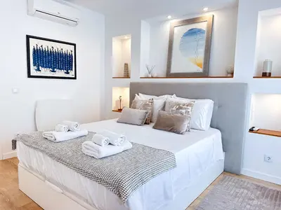 a large rattan mirror hanging on a wall at Luxury Albufeira Townhouse with Terraces, Pool & Views by Be Cherish in Albufeira