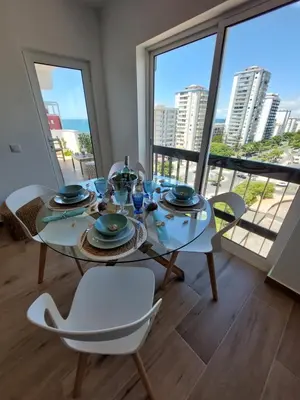 a dining room with a table and chairs with a view at Sun&Sea in Quarteira