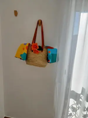 a purse hanging on a wall next to a window at Sun&Sea in Quarteira