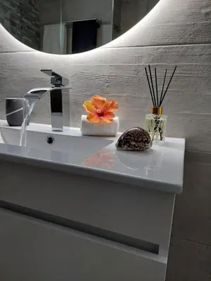 a bathroom sink with a faucet and flowers on it at Sun&Sea in Quarteira