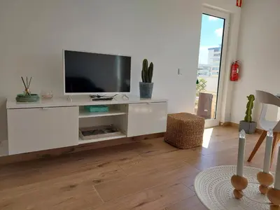 a white entertainment center with a flat screen tv at Sun&Sea in Quarteira