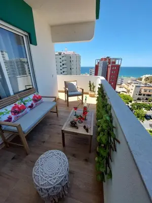 a balcony with a couch and a coffee table at Sun&Sea in Quarteira