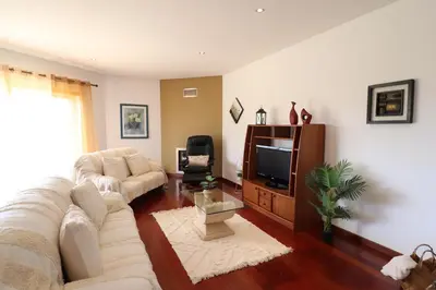a living room with a couch and a tv at 3-Bed Townhouse with pool in Albufeira Balaia in Albufeira