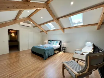 a bedroom with a bed and a chair in a room at Faro Design 7 by Homing in Faro