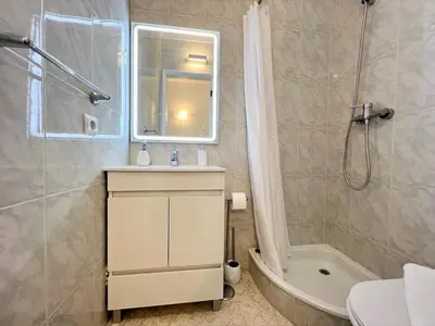 a bathroom with a sink and a shower and a tub at Quarteira Panoramic View by Homing in Quarteira