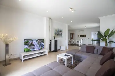 a living room with a couch and a flat screen tv at Villa Maya in Almancil