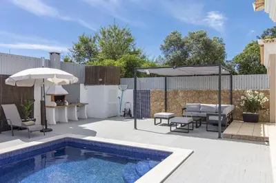a backyard with a swimming pool and an umbrella at Villa Maya in Almancil