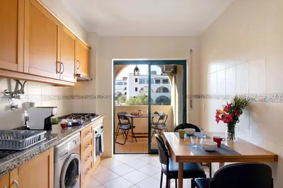 a kitchen with a table and a dining room at Casa dos Salgados in Albufeira