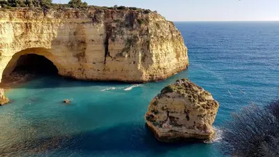 a large rock in the ocean next to a cave at Casa Old Town Splendida in Albufeira