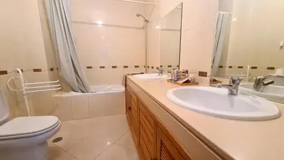 a bathroom with two sinks and a toilet and a tub at Casa Old Town Splendida in Albufeira