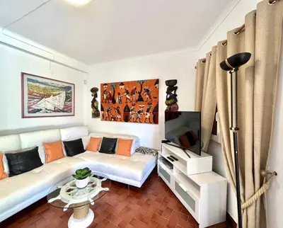 a living room with a white couch and a tv at Vila Rose - Private Pool by HD PROPERTIES in Vilamoura