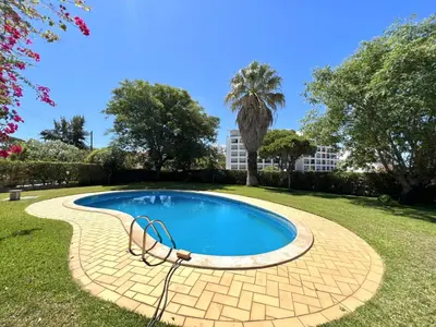 a swimming pool in a park with trees and a building at Vila Rose - Private Pool by HD PROPERTIES in Vilamoura