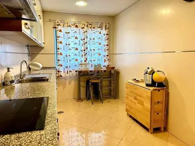 a large kitchen with a counter and a table at Mar e Sol by - T3 , wi-fi e estacionamento in Quarteira