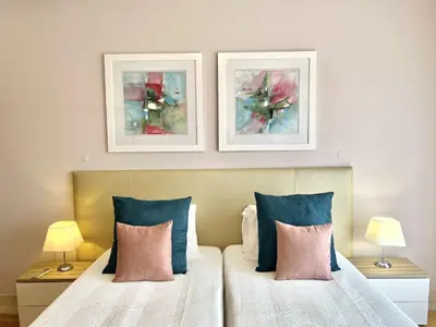 a bedroom with a bed with two pictures on the wall at Victoria I - Vasco da Gama by HD PROPERTIES in Vilamoura