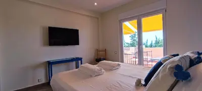 a bedroom with a bed with a tv and a window at Blue & Yellow Penthouse with Terrace at Balaia Mar in Albufeira