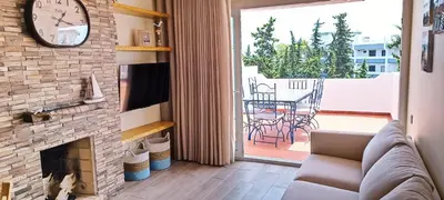 a living room with a fireplace and a clock at Blue & Yellow Penthouse with Terrace at Balaia Mar in Albufeira