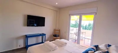 a bedroom with a bed and a television and a balcony at Blue & Yellow Penthouse with Terrace at Balaia Mar in Albufeira