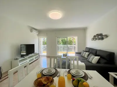 a living room with a table and a couch at Vilamoura Central 2 With Pool by Homing in Vilamoura