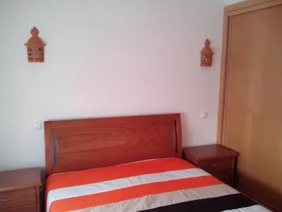a bedroom with a bed with a red and white striped blanket at Charming 2-Bed Apartment in Olhos de Agua in Albufeira