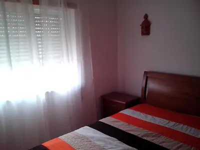 a bedroom with a bed and a window with curtains at Charming 2-Bed Apartment in Olhos de Agua in Albufeira