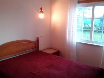 a bedroom with a bed with a red blanket and a window at 2 Bed Flat - Sleeps 4 - Parking - Wifi in Albufeira