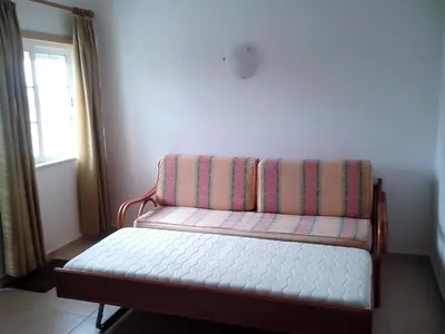 a couch sitting in a room with a window at 1 Bed Flat - Sleeps 2 - Parking - Wifi in Albufeira