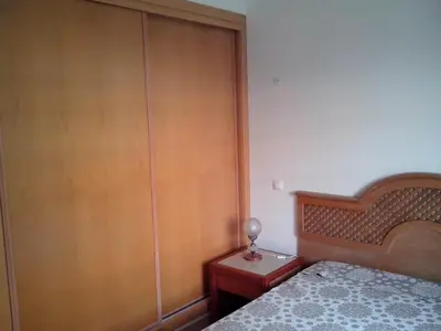 a bedroom with a bed and a wooden closet at 1 Bed Flat - Sleeps 2 - Parking - Wifi in Albufeira