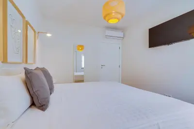 a white bedroom with a large white bed in it at AL - Apartamento Pontemira in Quarteira