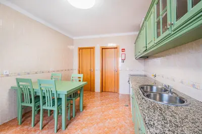 a kitchen with a table and chairs and a sink at Villa Kevin by Atlantic Places in Albufeira