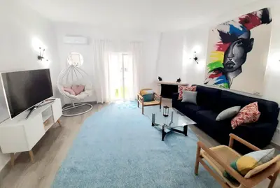 a living room with a black couch and a tv at Alojamento local 