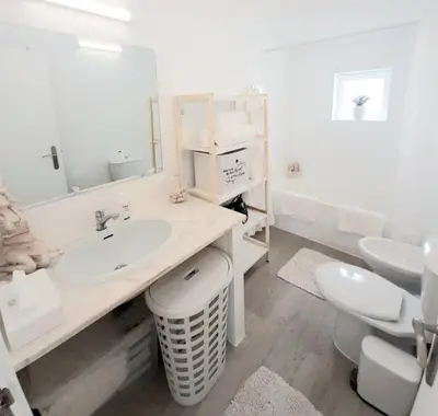 a white bathroom with a sink and a toilet at Alojamento local 