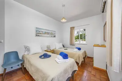 a hotel room with two beds and a window at Villa Alegre by Villa Plus in Albufeira