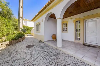 a house with a white door and a courtyard at Villa Casa Sophia by Villa Plus in Olhos de Água