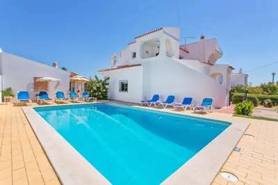 a villa with a swimming pool in front of a house at Villa Terra by Villa Plus in Albufeira
