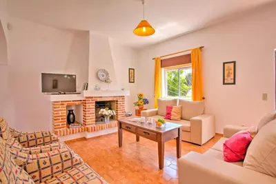 a living room with a couch and a fireplace at Villa Terra by Villa Plus in Albufeira