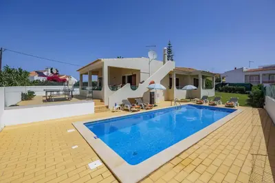 a villa with a swimming pool in front of a house at Villa Campos by Villa Plus in Guia