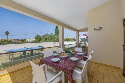 a dining room with a table and chairs on a balcony at Villa Campos by Villa Plus in Guia