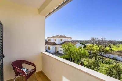 a balcony with a chair and a view of a house at Villa Casa Grande by Villa Plus in Albufeira