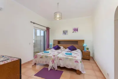 a bedroom with a bed with purple pillows at Villa Casa Grande by Villa Plus in Albufeira