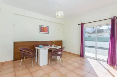 a dining room with a table and chairs and a window at Villa Casa Grande by Villa Plus in Albufeira